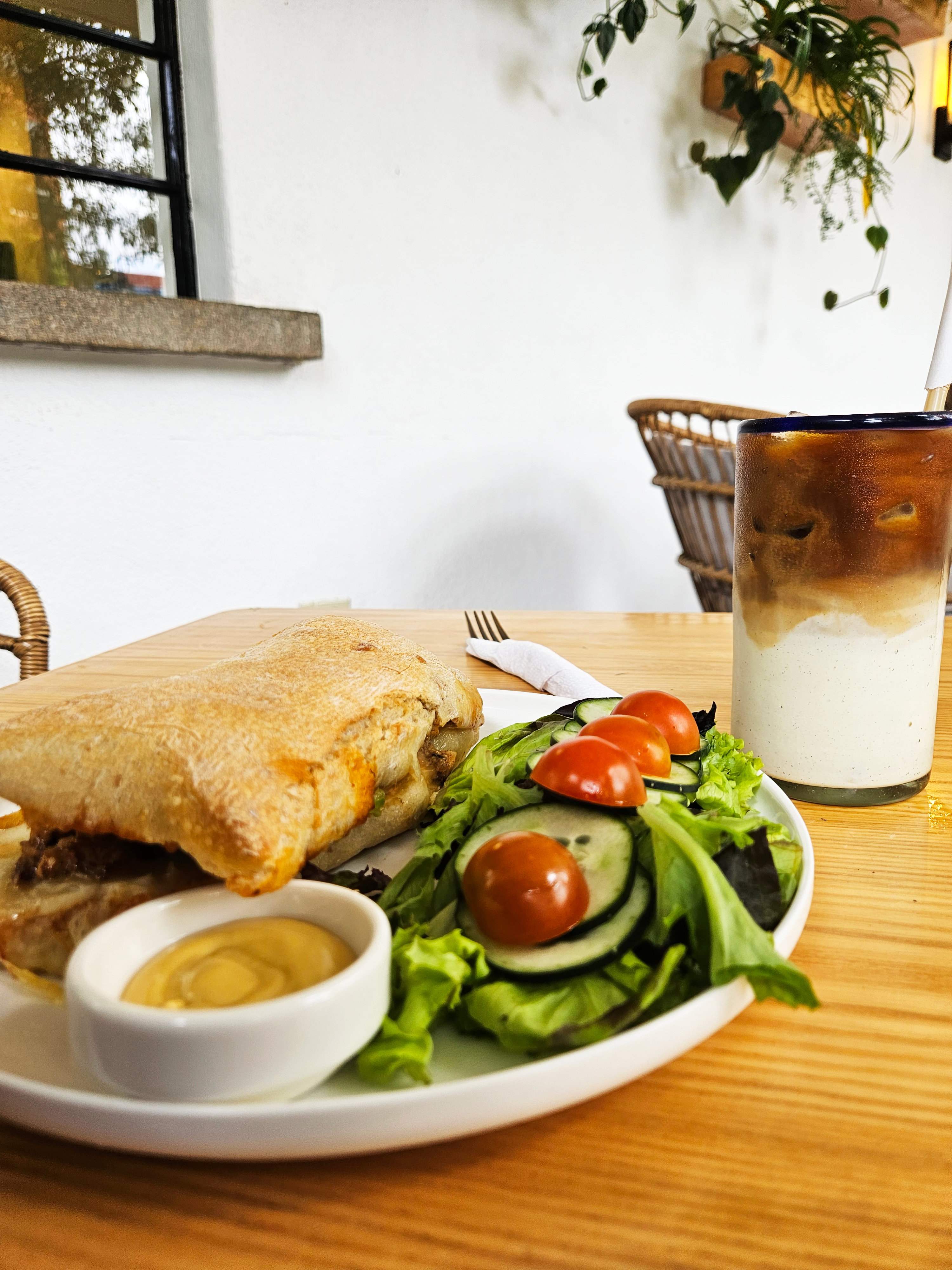 Pan con ensalada y aderezo acompañado con café con hielo